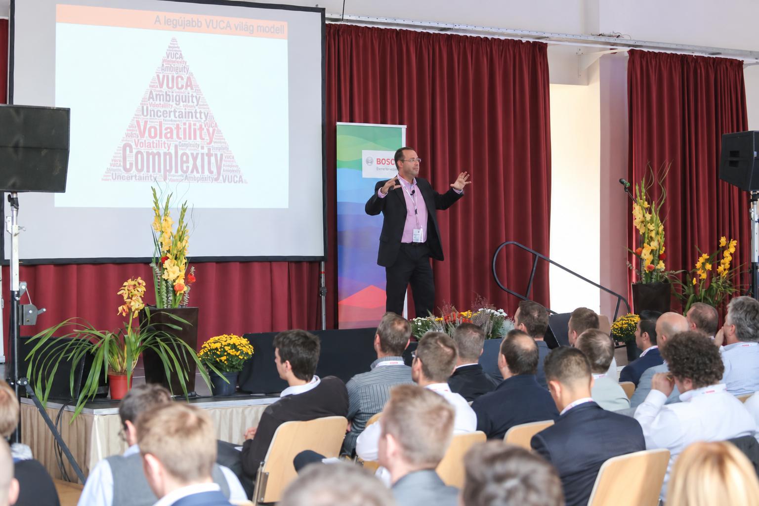 Bence László Tarr presenting beside the VUCA pyramid to the audience at the first RBHH Leadership Day