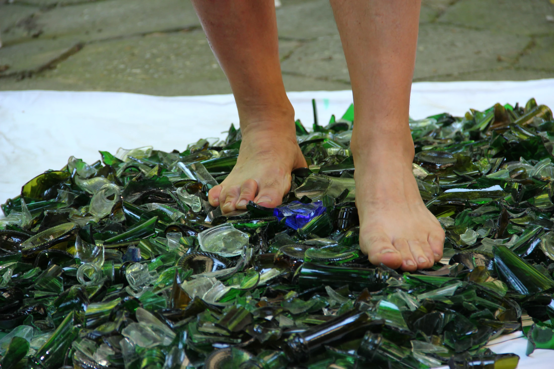 Both feet placed with attention among prepared pieces of glass