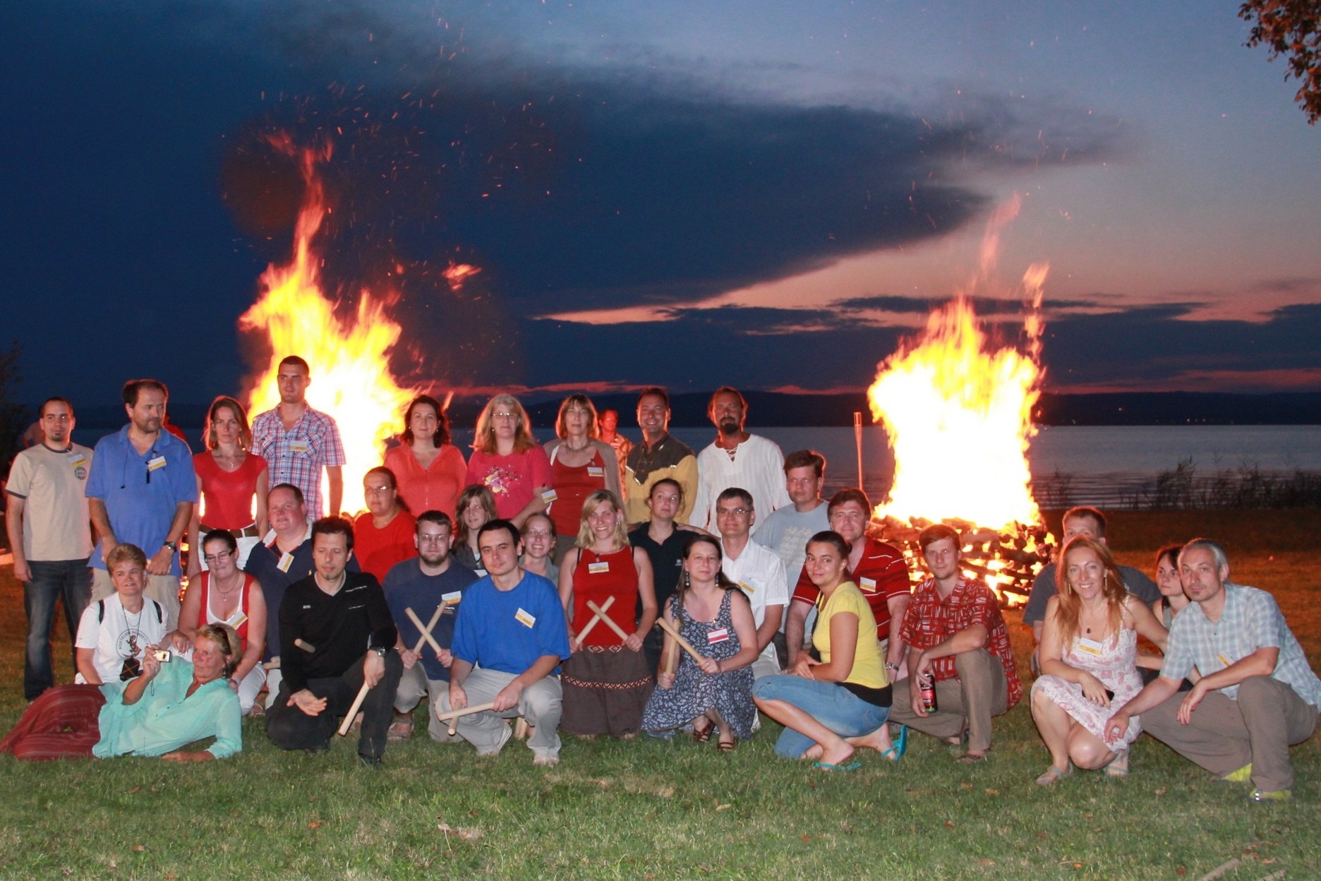 A corporate charity firewalking group gathered beside two fires