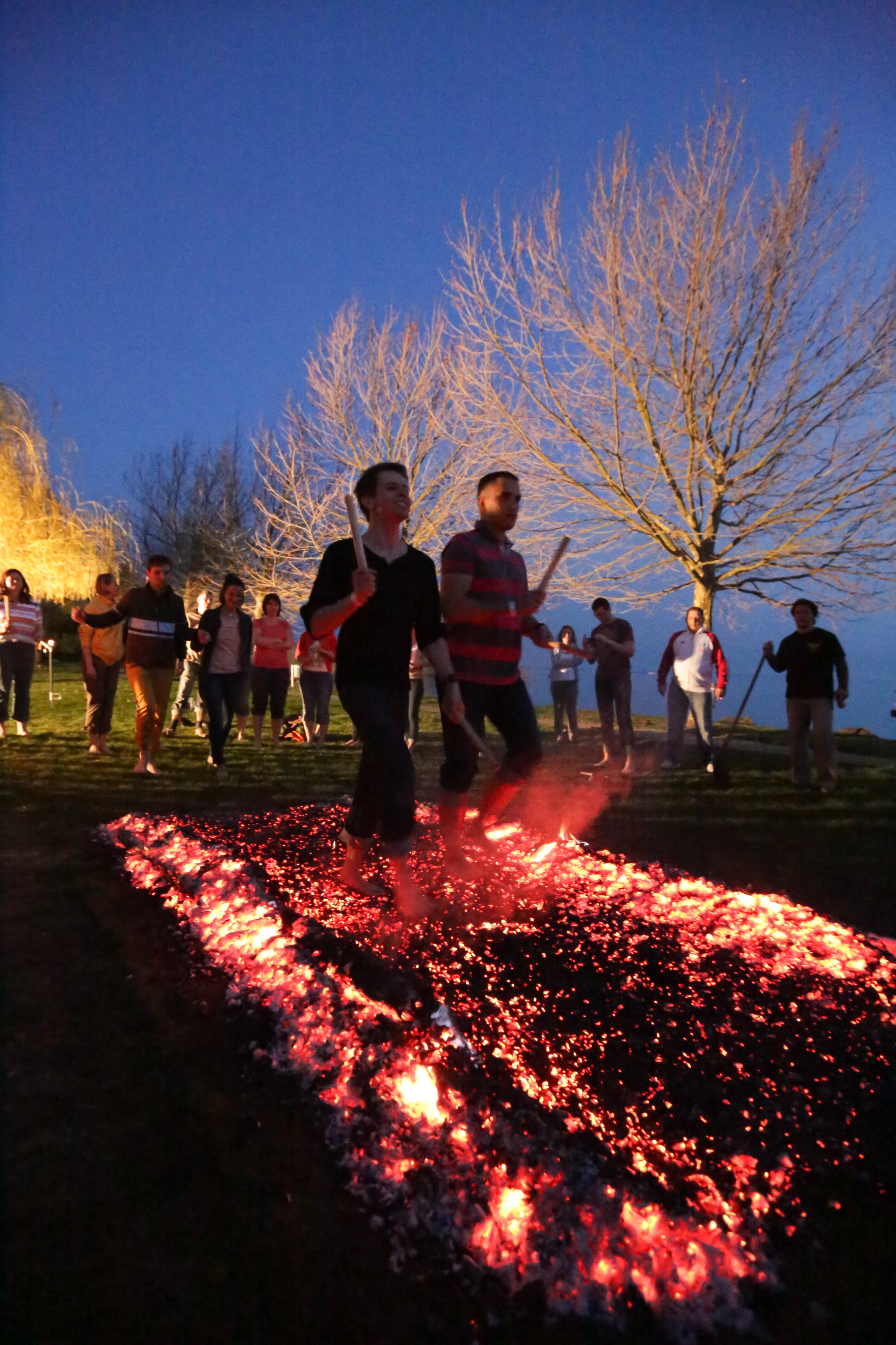 Two colleagues walking across a large patterned ember bed with the team behind them