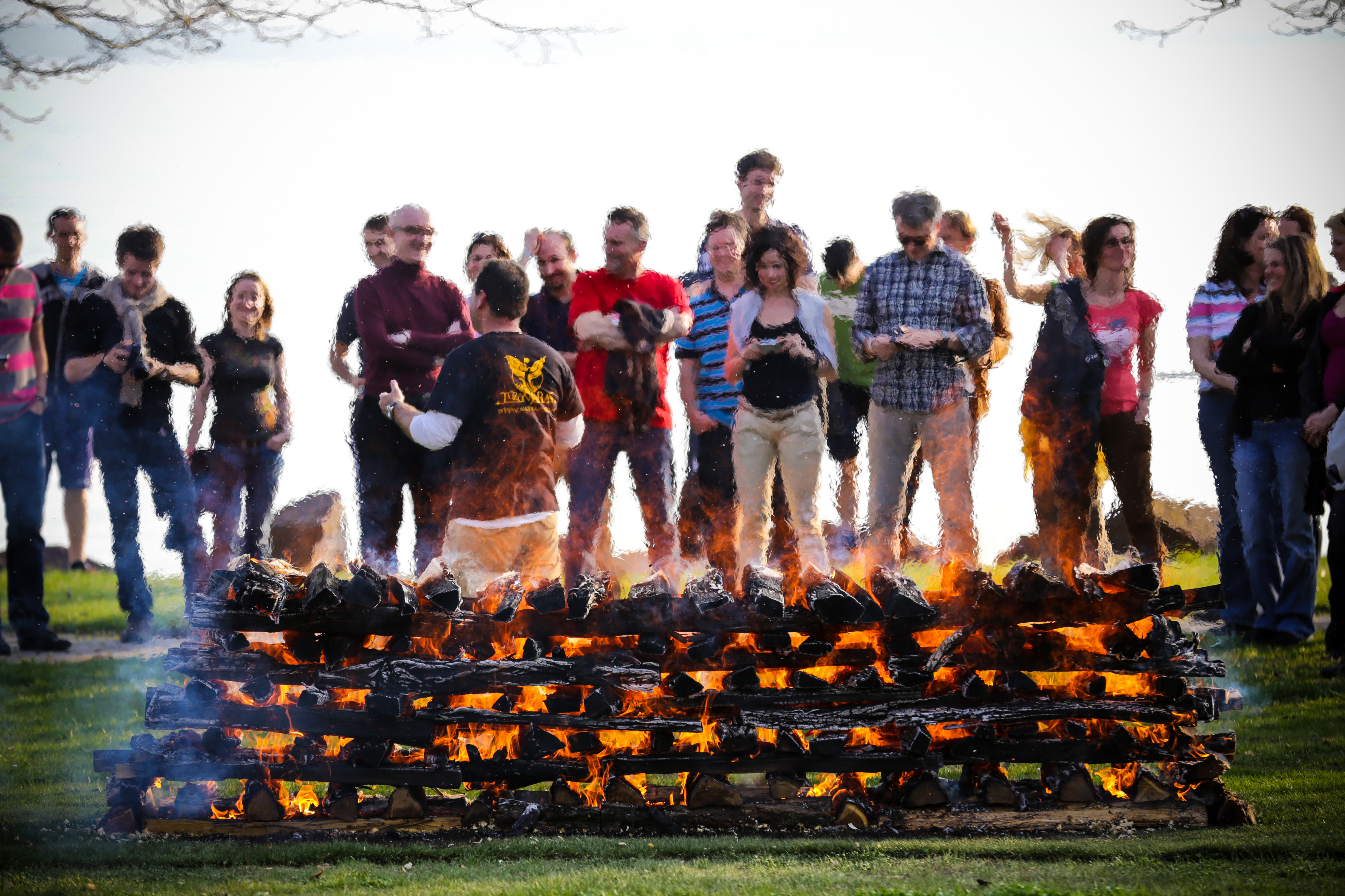 A corporate team gathered together behind a burning pyre