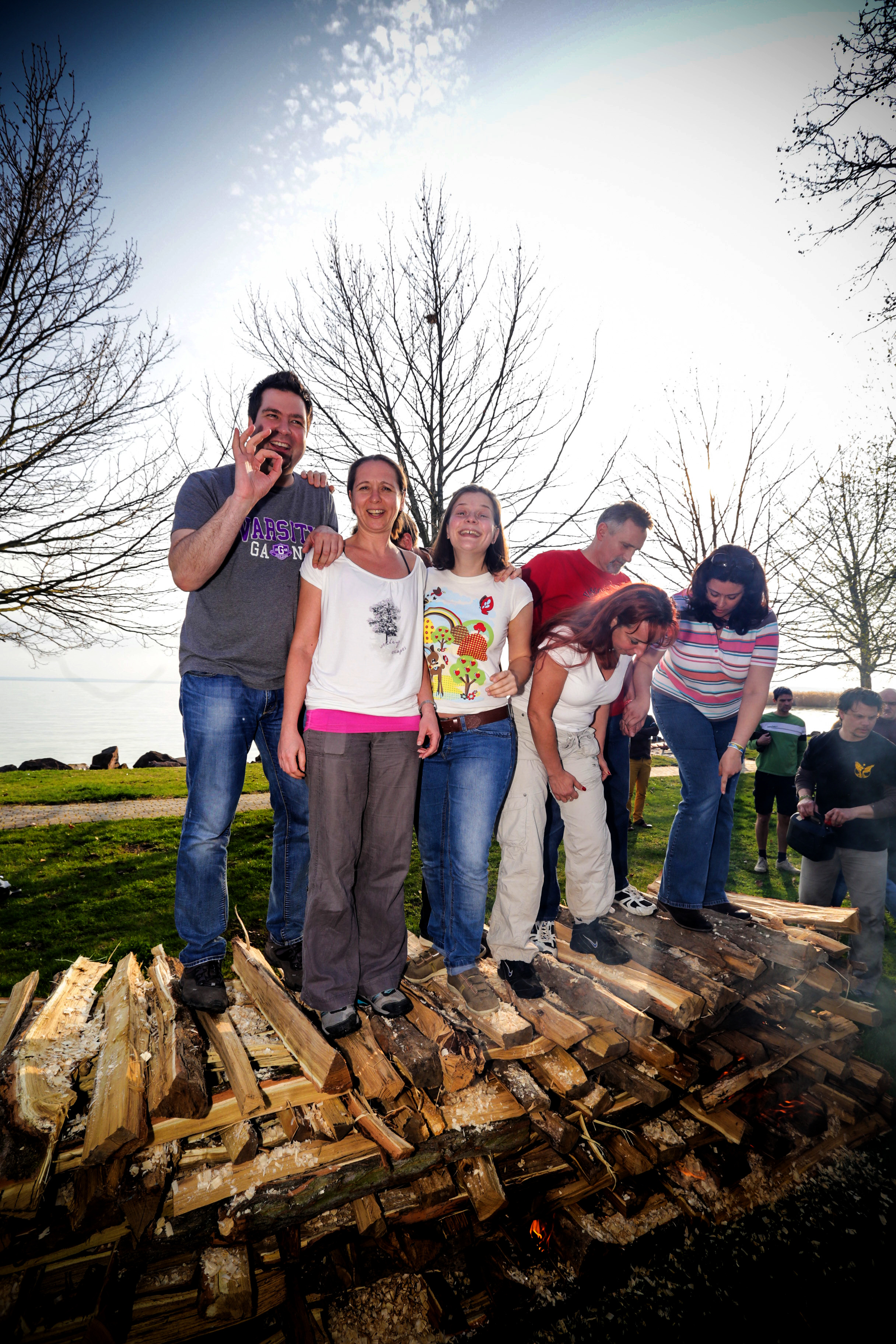 Colleagues standing together on the stacked wood before the fire