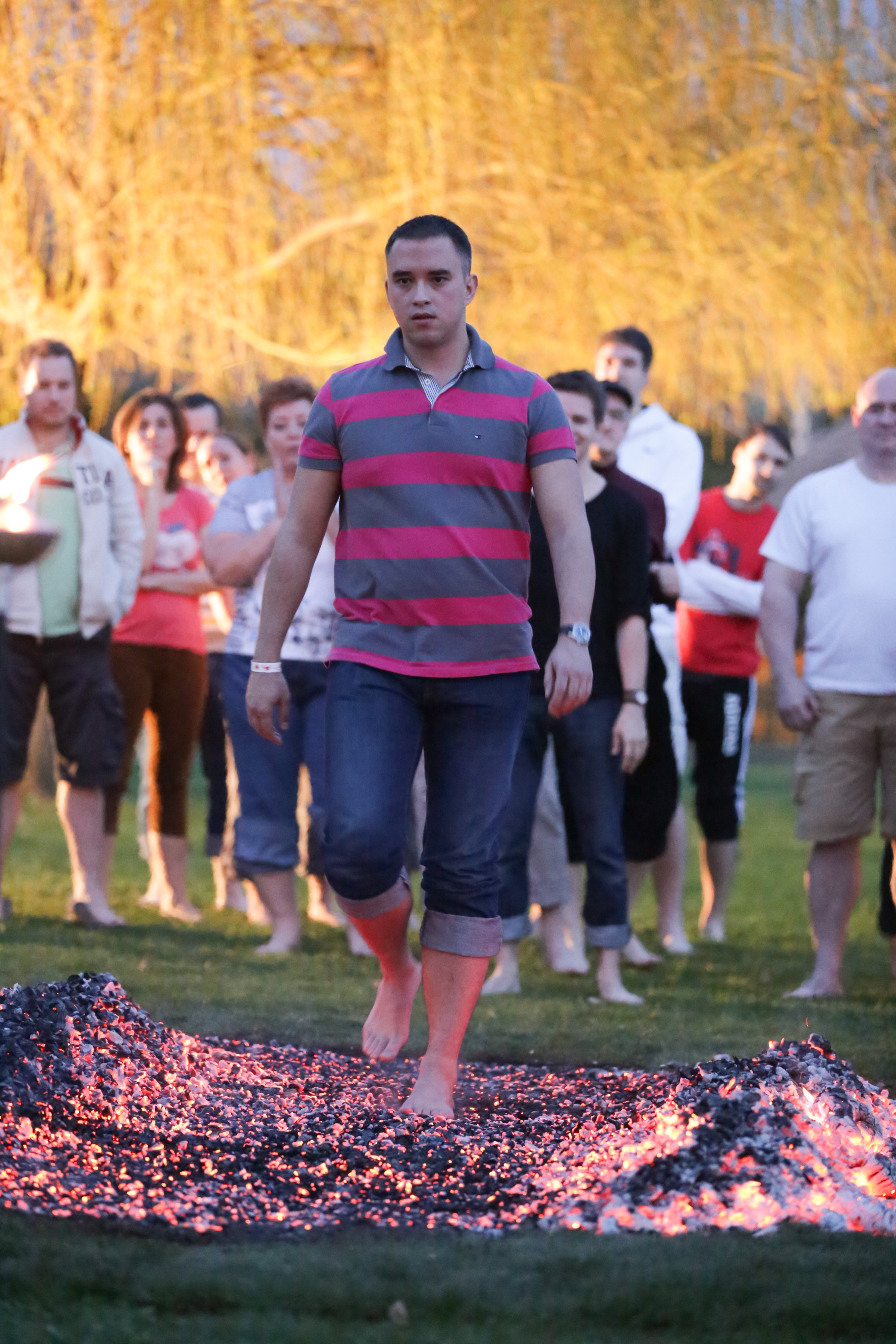 A participant approaching the glowing ember path with colleagues behind him