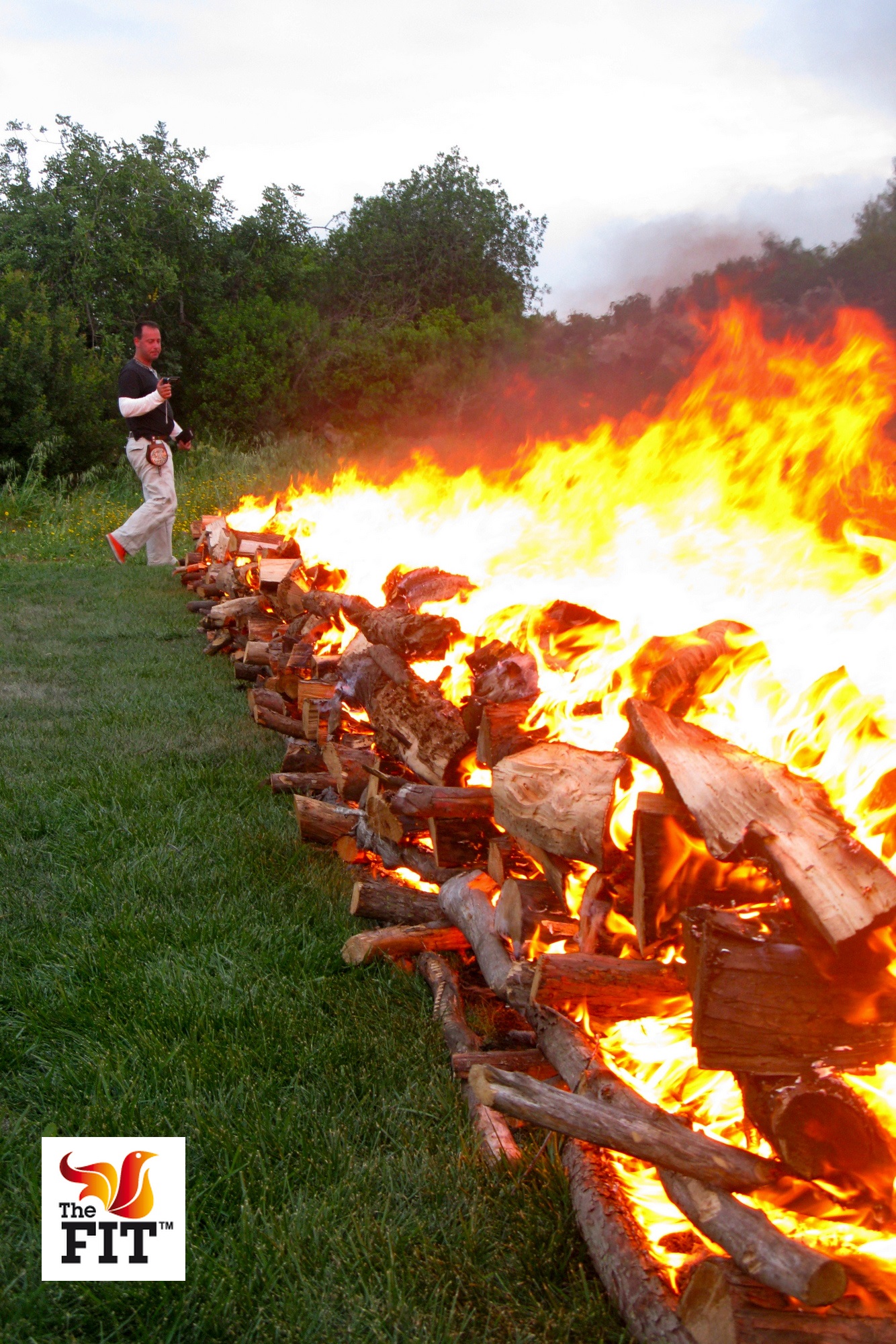 A twelve-metre firewalking pyre burning across the grass