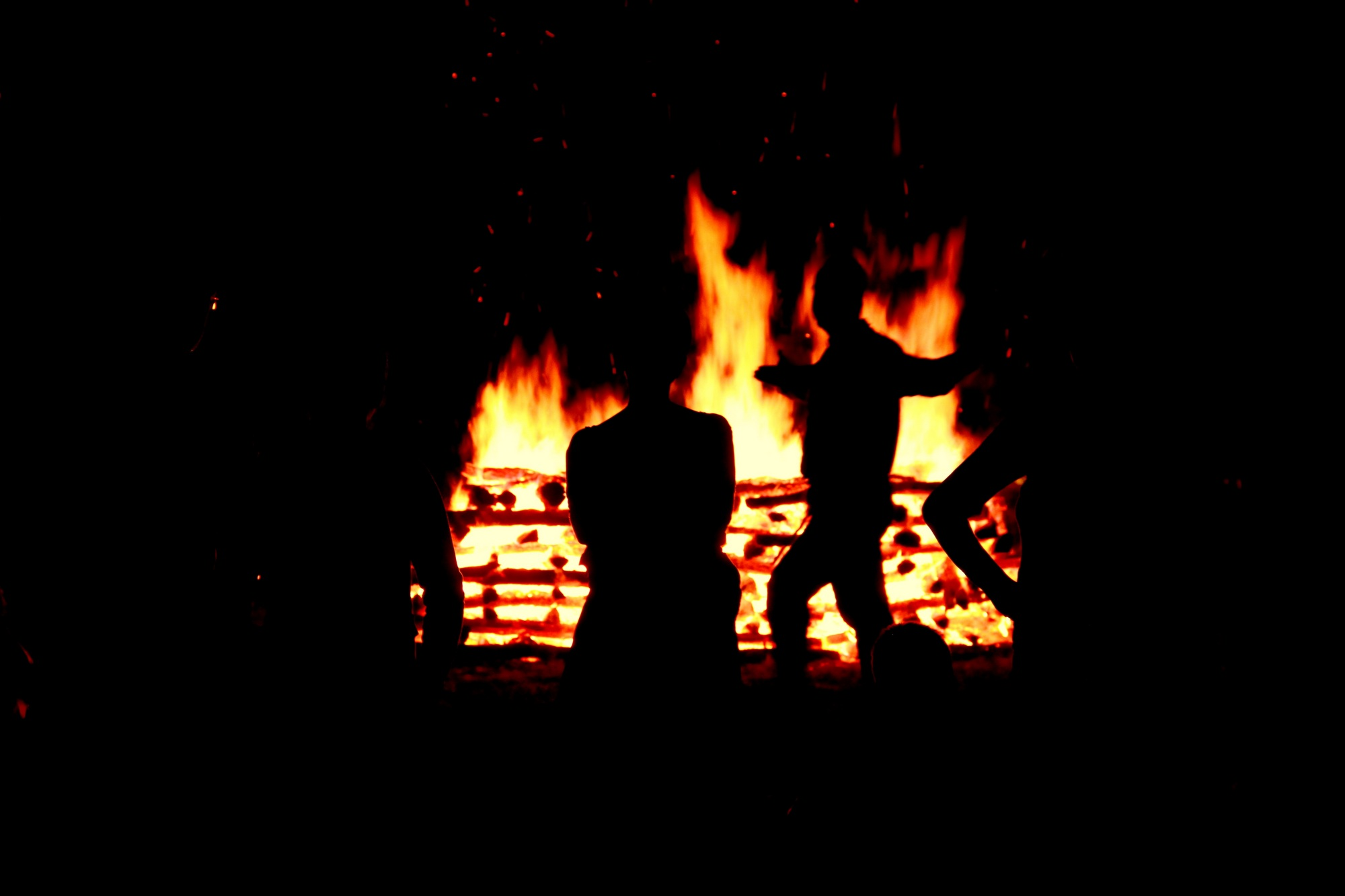 A facilitator leading participants through a direct experience beside a large fire