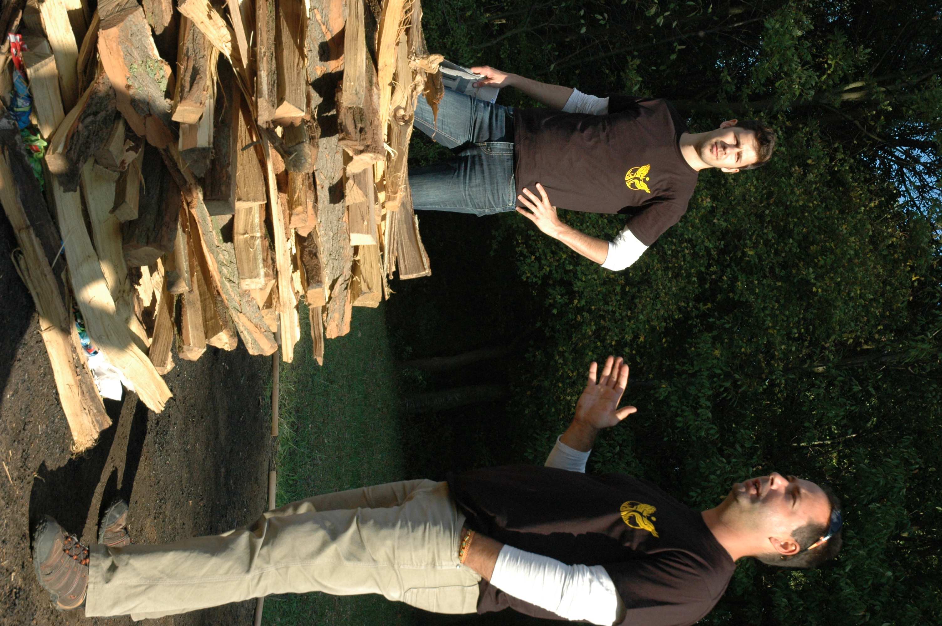 Two instructors explaining the construction of a firewalking pyre