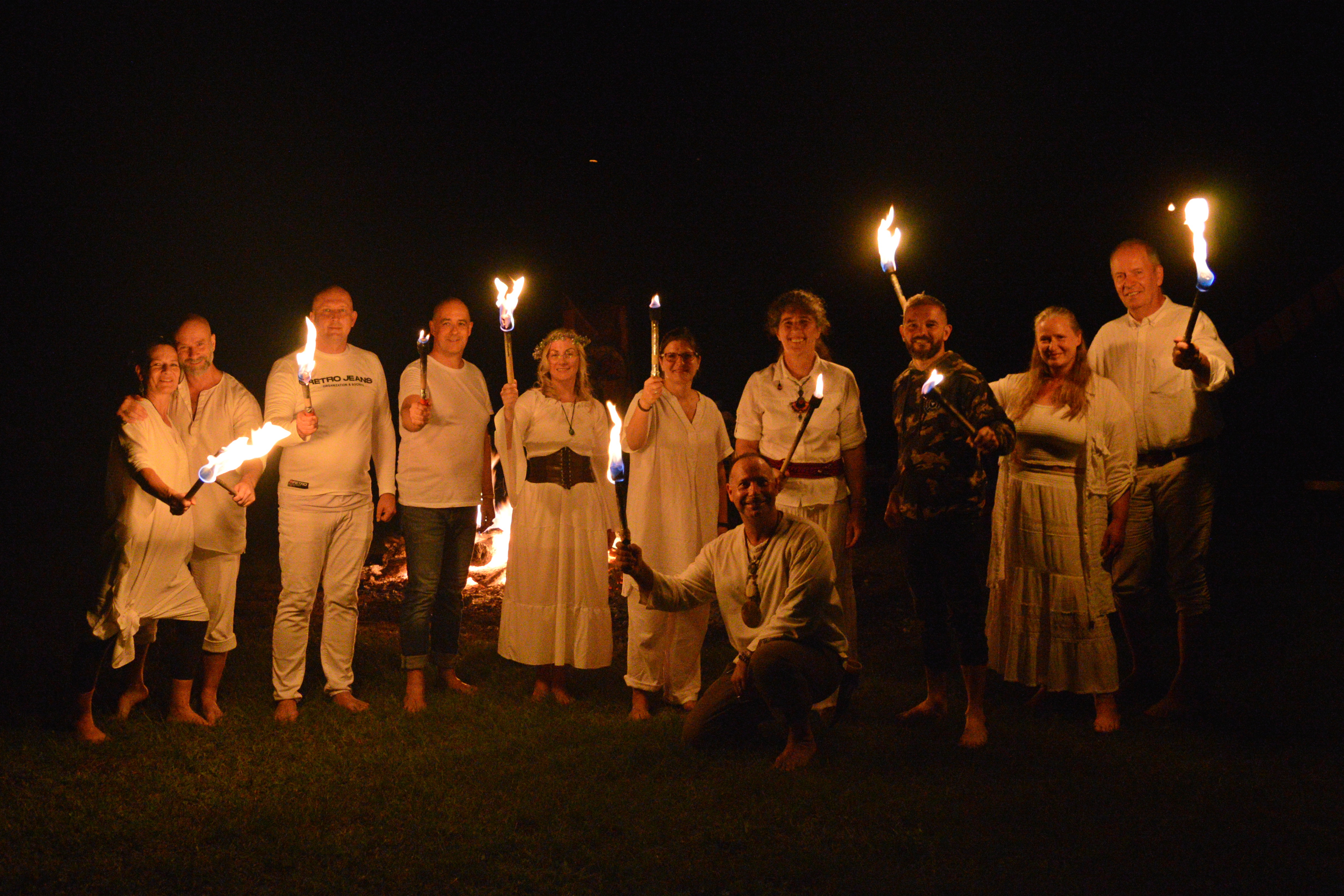 Participants standing together at night with ceremonial torches