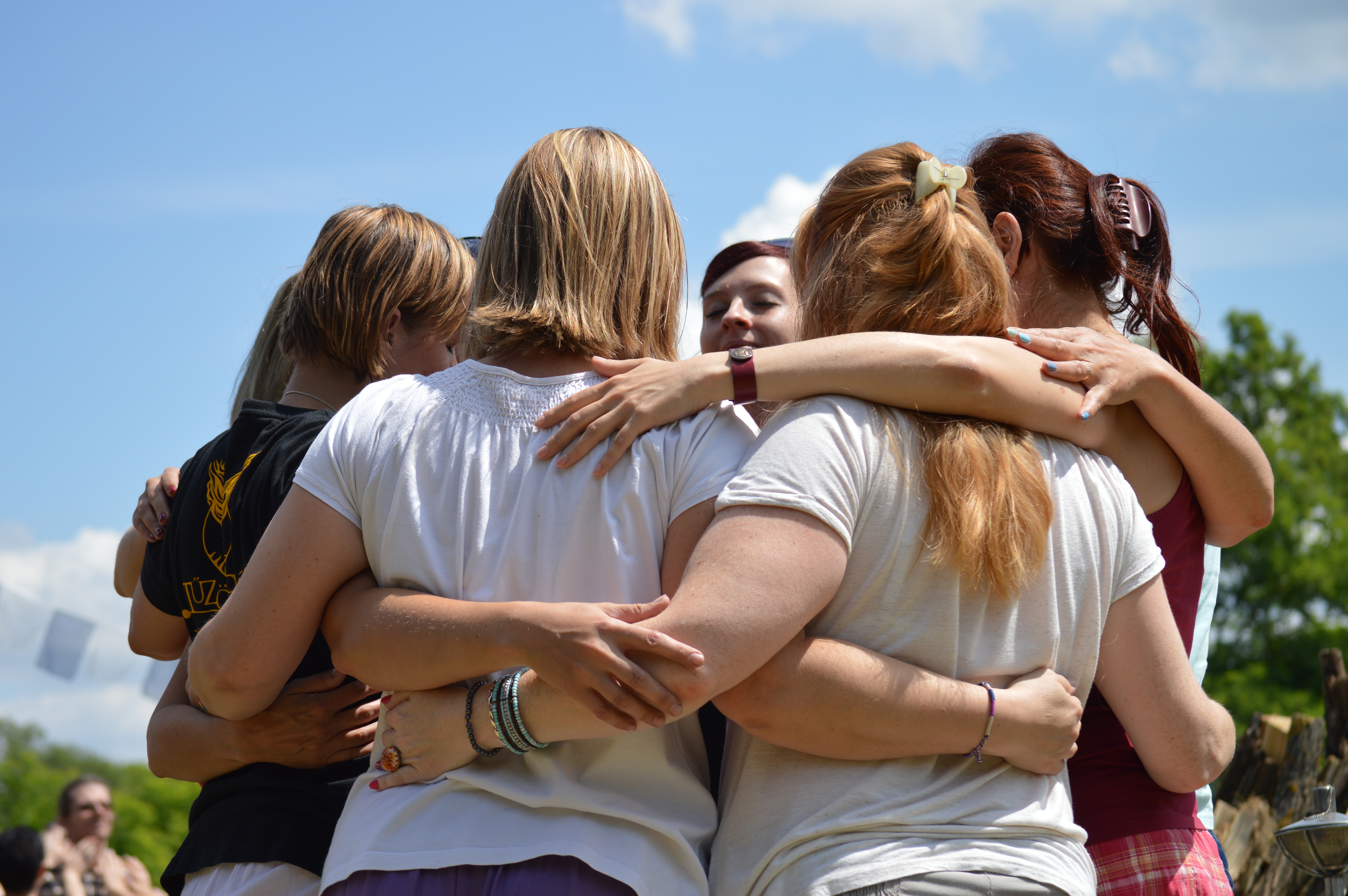 Participants embracing in a supportive outdoor circle