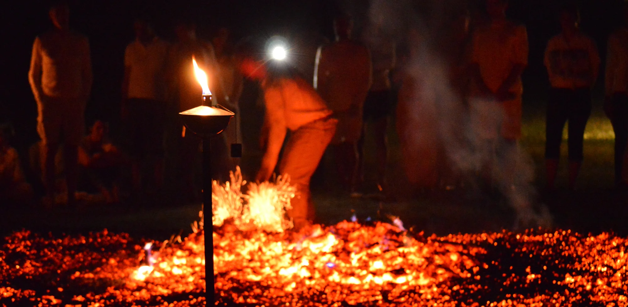 A summer gathering moving around a glowing fire