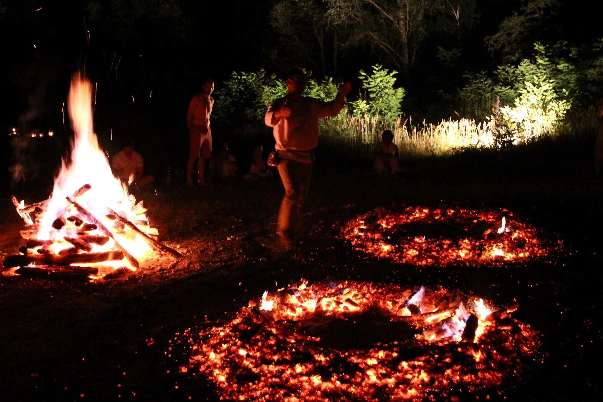 A participant walking between a bright fire and a circular ember path