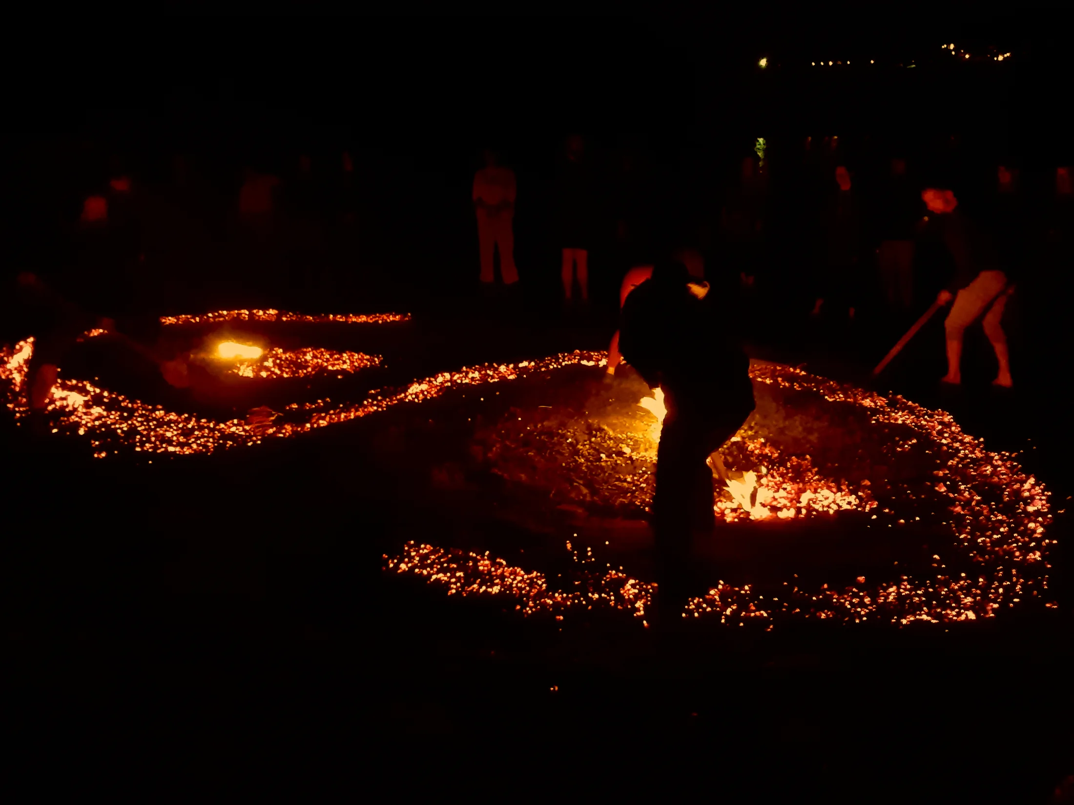 A glowing ember design being carefully shaped at night