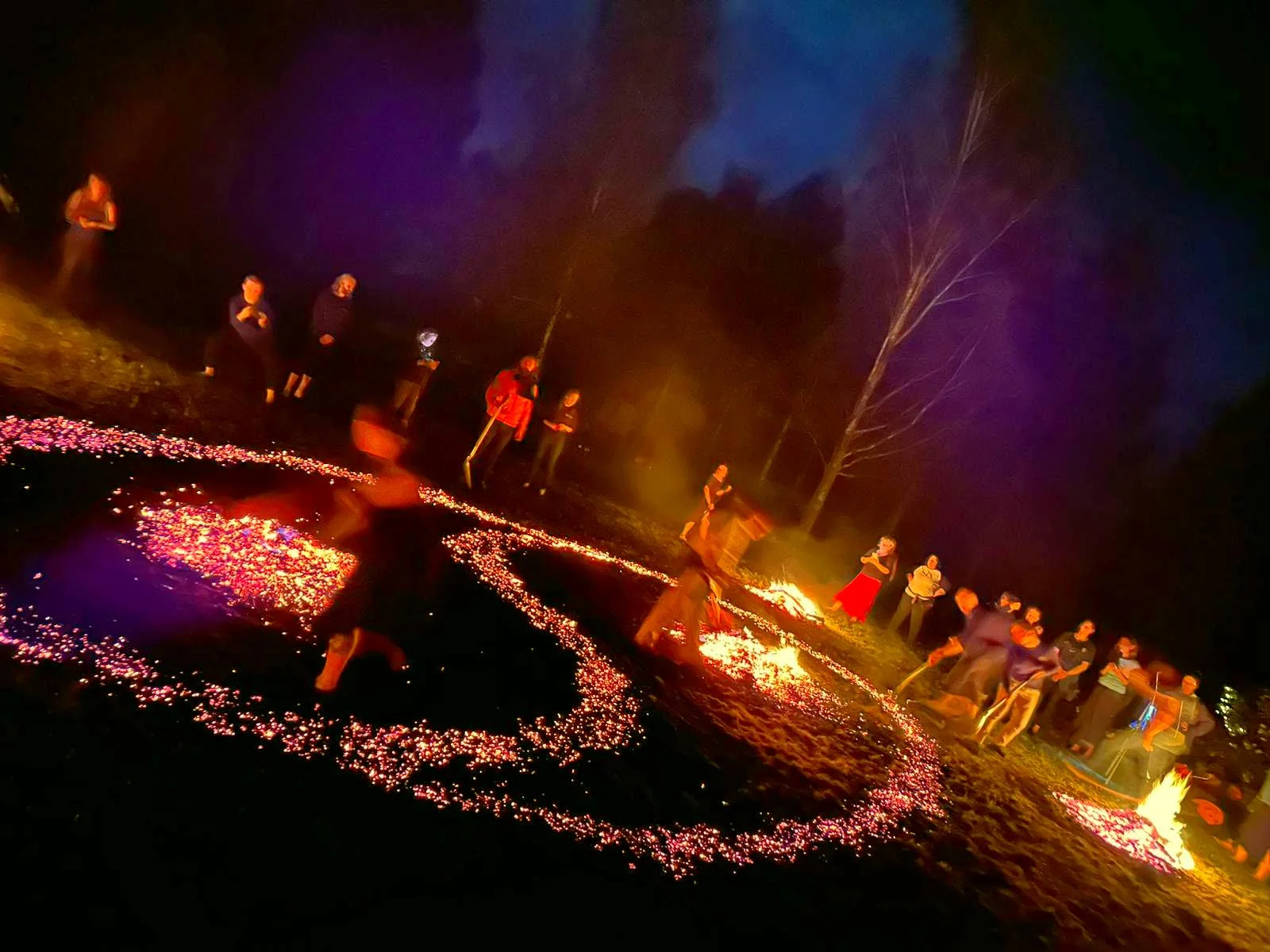 A winding ember path glowing with coloured light at night