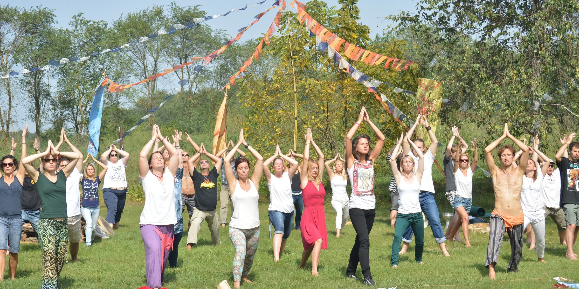 A large outdoor group moving together with raised hands