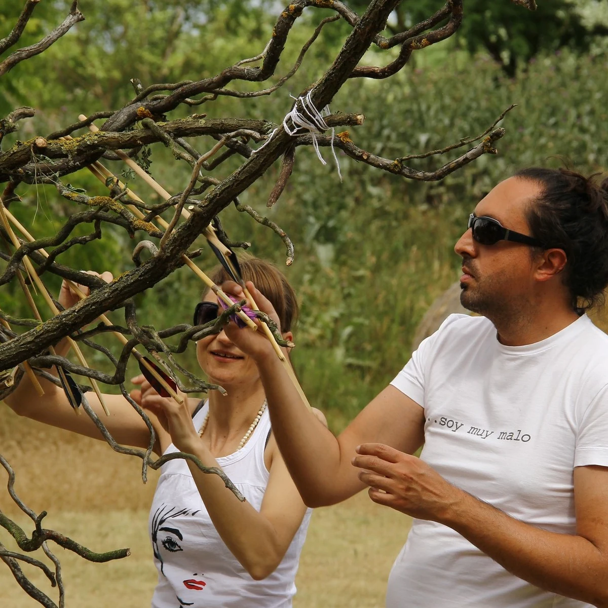 Participants placing written intentions into a ceremonial branch structure