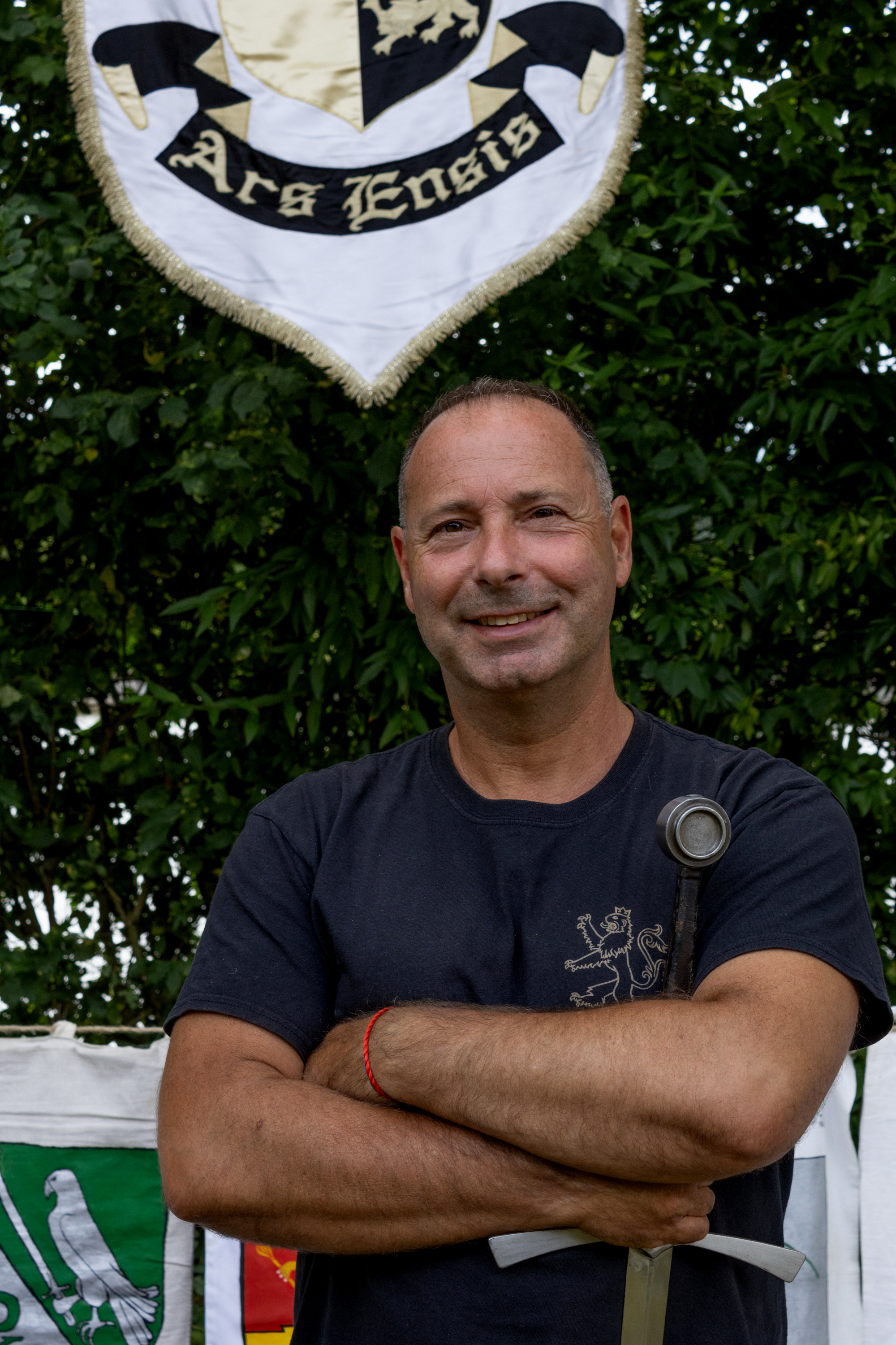 Bence László Tarr as a HEMA martial artist, holding a longsword beneath the Ars Ensis banner