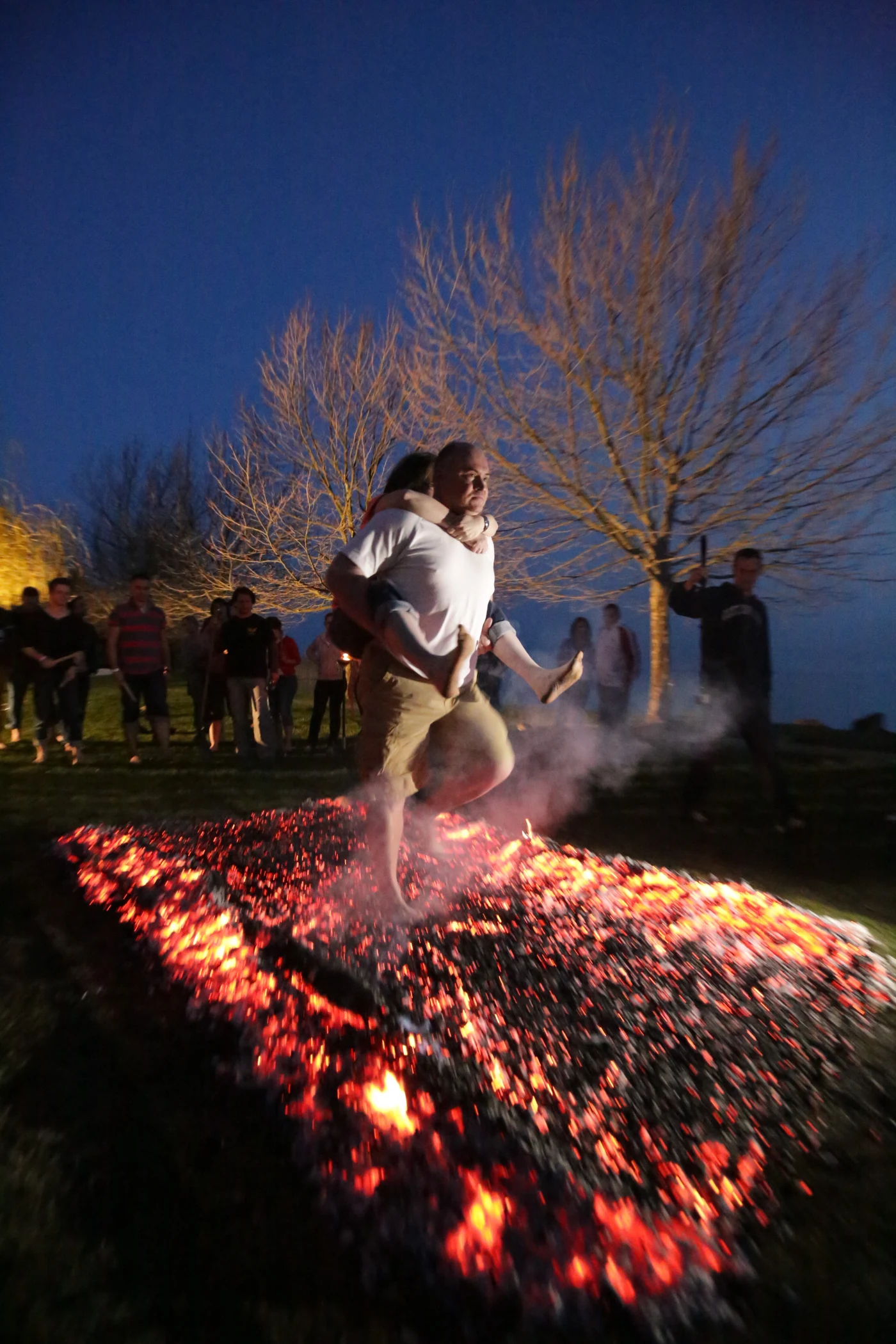 Two colleagues crossing a glowing ember bed together