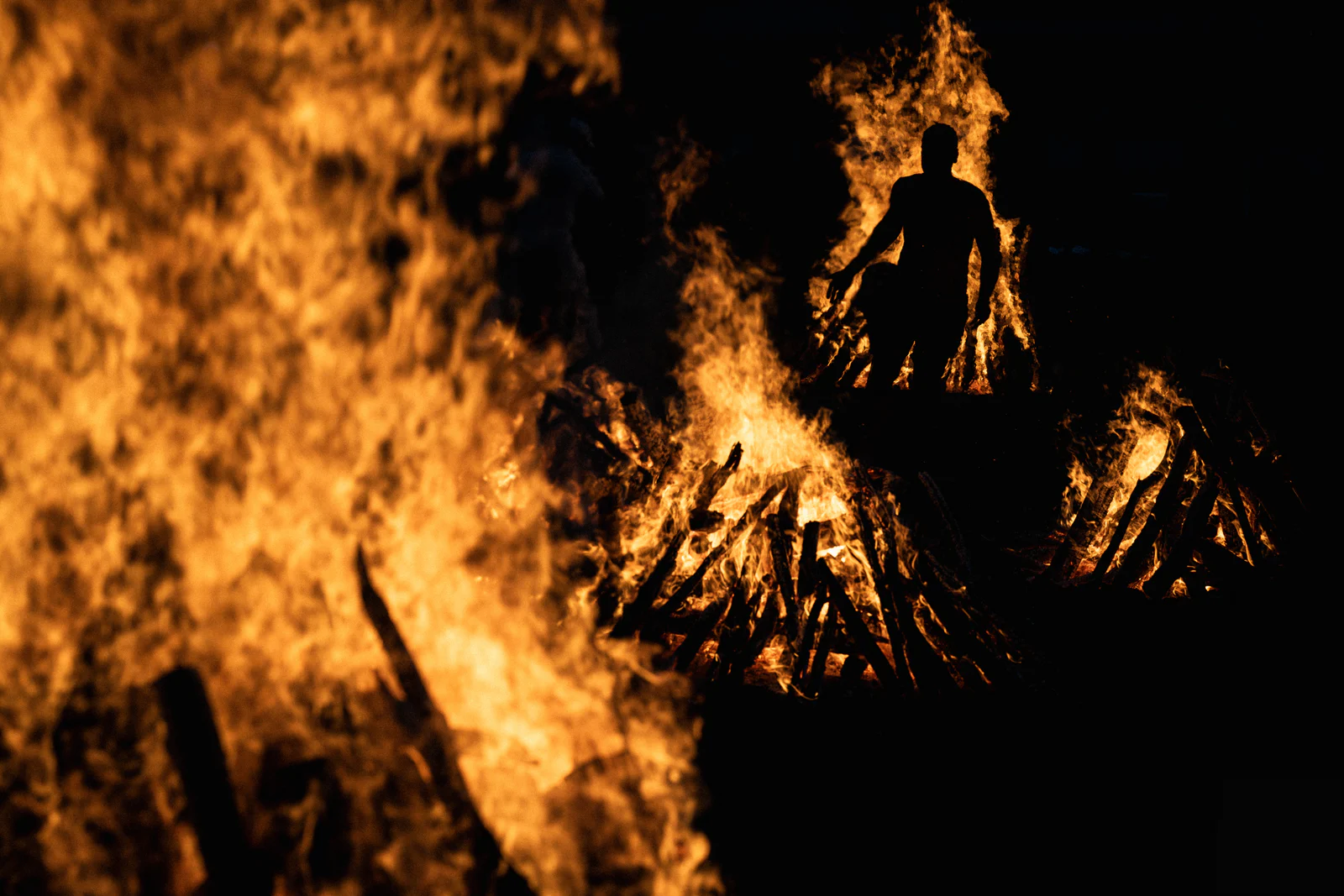 Silhouette of a man standing before the fire