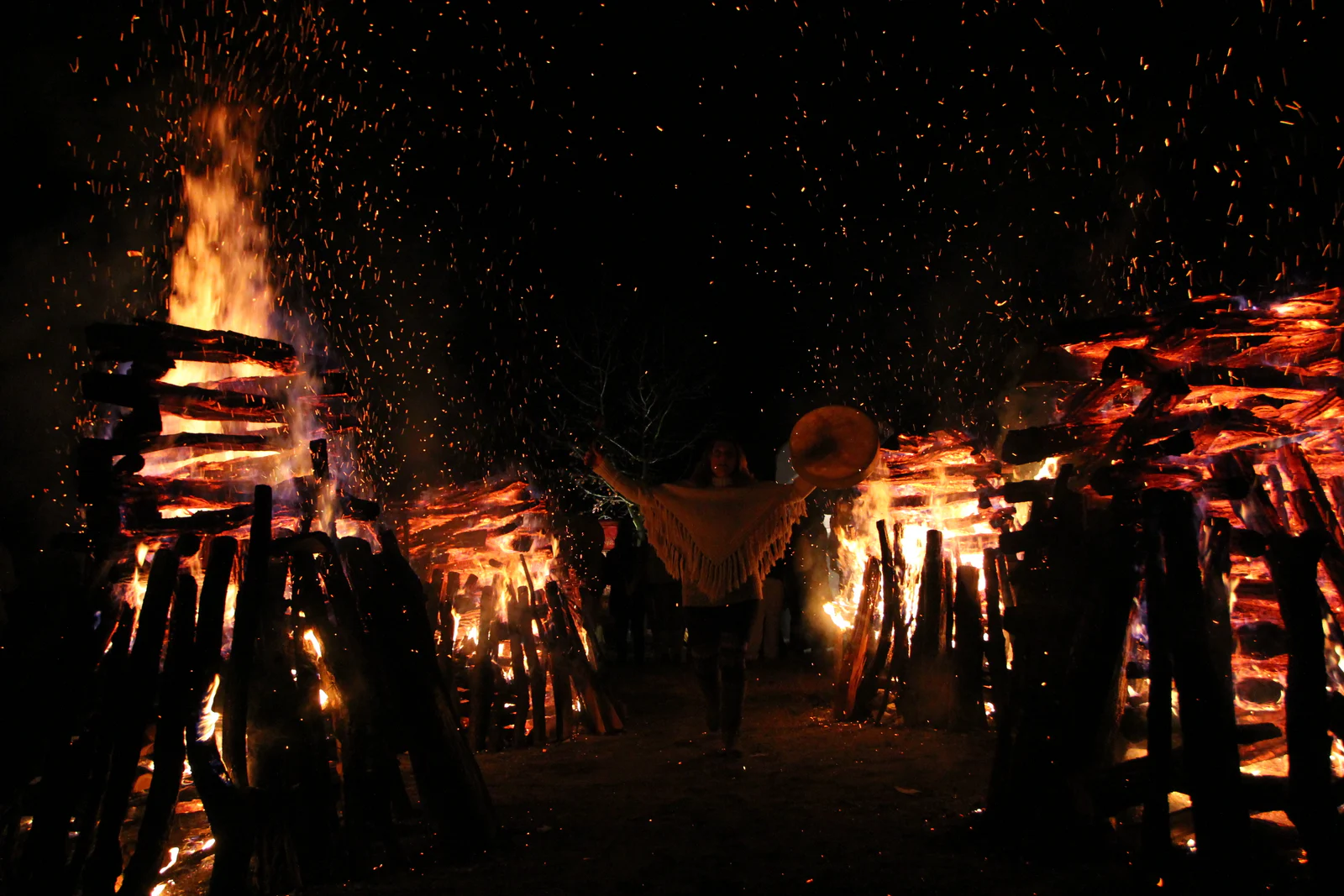 Drummer moving between two blazing fires