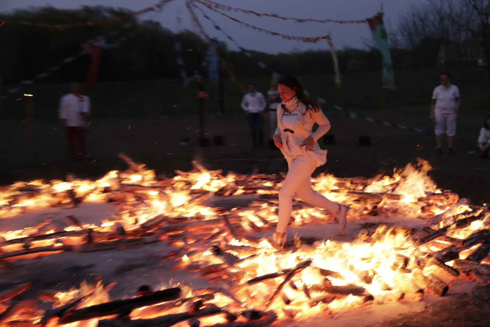 Participant in white crossing the fire bed