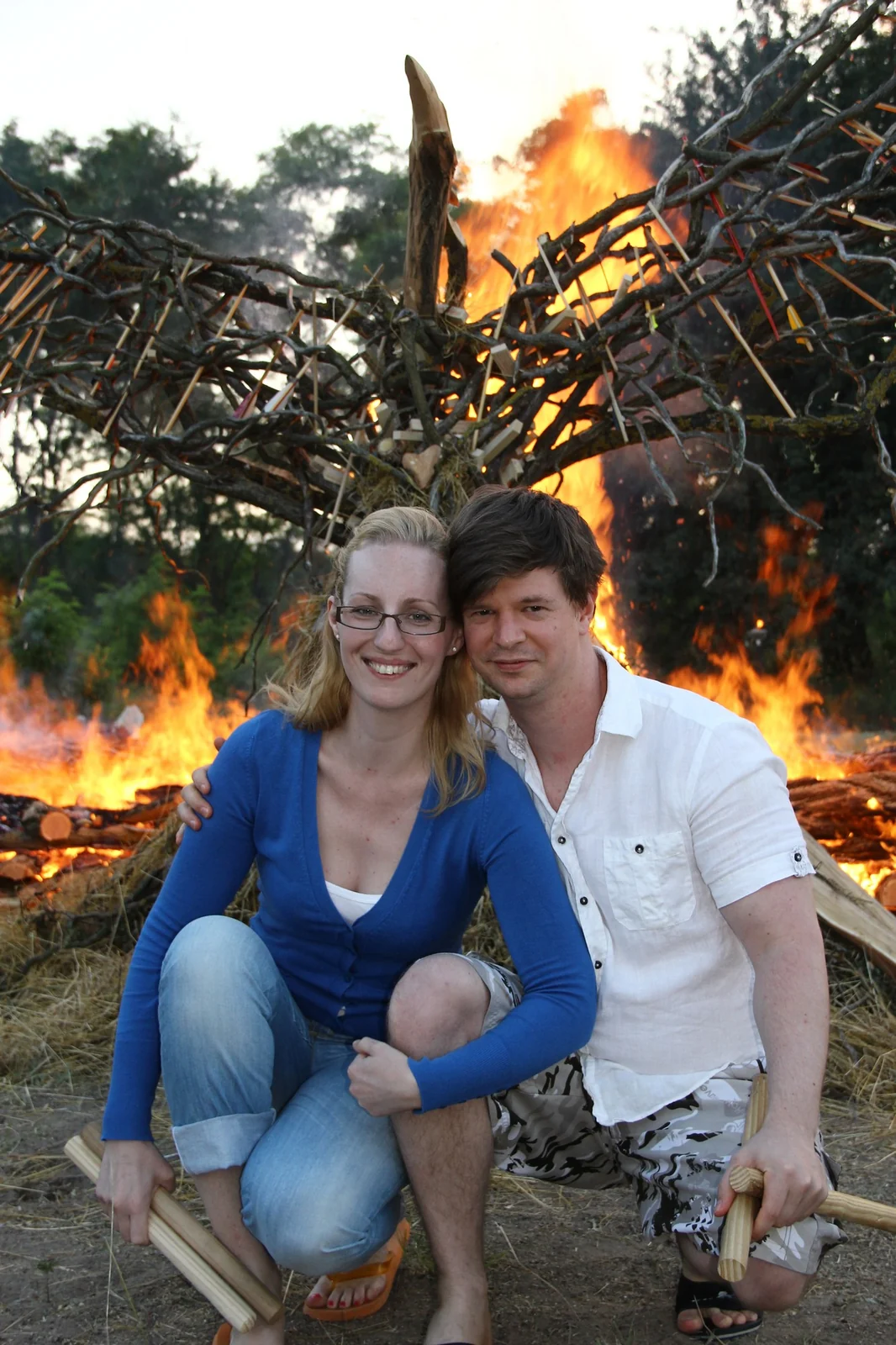 A couple sitting together beside a ceremonial fire