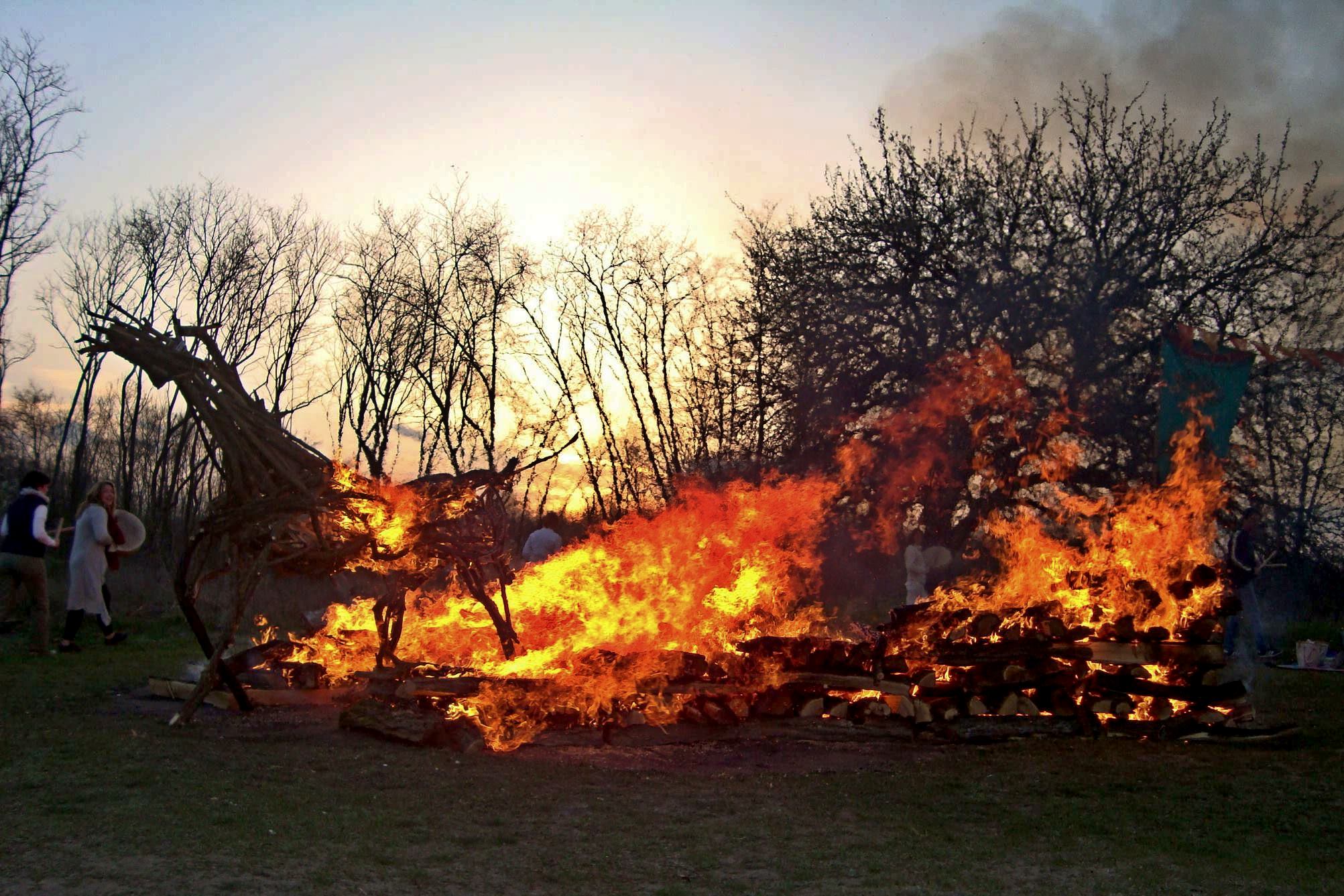 A complete horse-shaped wooden fire sculpture burning beside a firewalk