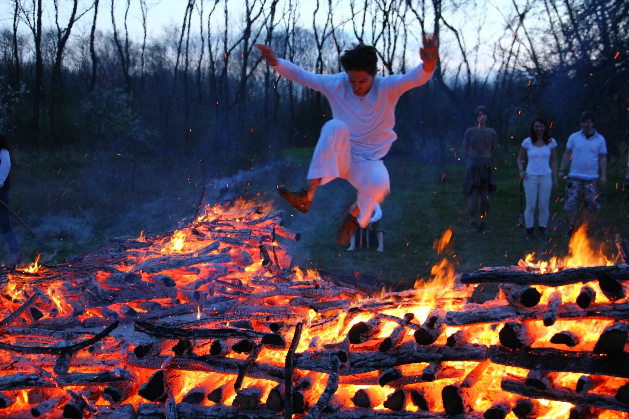 A participant moving above a ceremonial fire during a professionally held programme