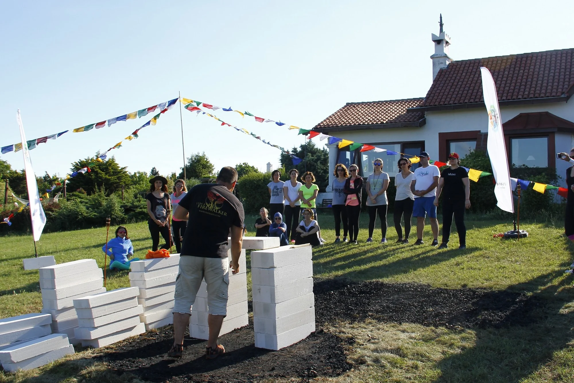 A facilitator and participants gathered beside a prepared ember path